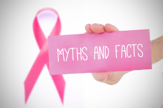 Young woman holding pink card against pink awareness ribbon