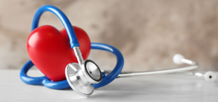 Stethoscope and red heart on table