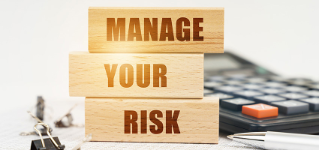 Business and finance concept. On the reports is a pen, calculator, clips and wooden boards with the inscription - Manage Your Risk