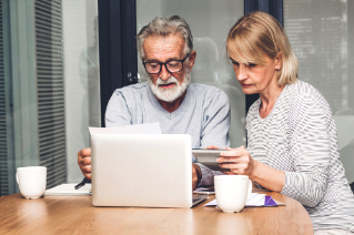 Senior couple reading documents and calculating bills to pay in living room at home.Retirement couple and loan bankruptcy money concept