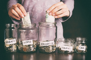 Hand's women putting coin in money jar with text . Concept of investments, insurance, savings plans.