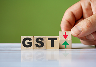The hand turn wooden block with red and green arrow as change concept of GST. Word GST conceptual symbol.