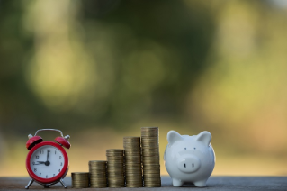 A piggy bank put on the stacking gold coins and blackboard house