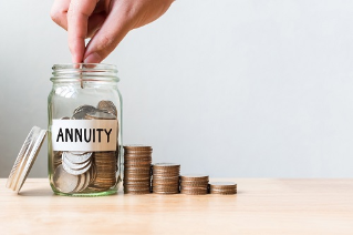 Hand putting coin in jar word annuity with money stack, Concept business finance and investment