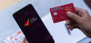 Birbhum, West Bengal, India - 25 April 2022: Top view of a smart phone with IPPB application and a post office debit card held in hand